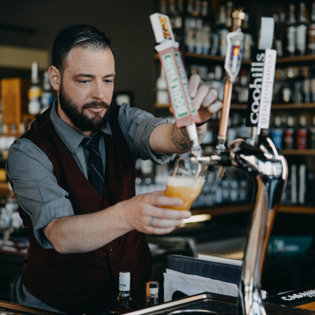 Bartender pouring beer from draft