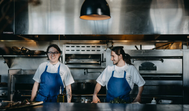 Two kitchen staff members working in kitchen