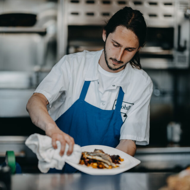 Chef prepares plate of food to serve