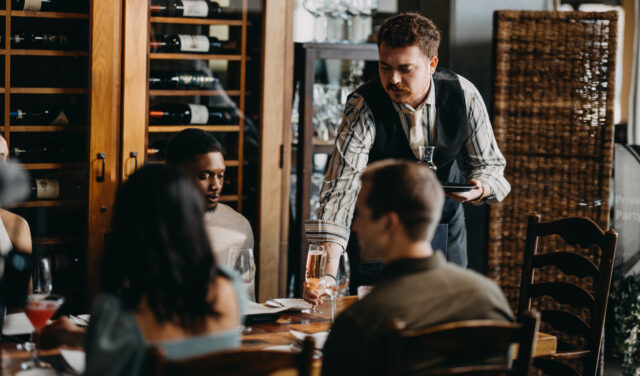 Hosts seats table at restaurant