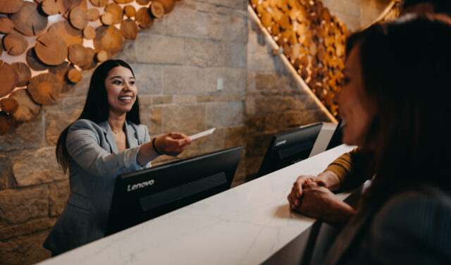 Women handing hotel keycard to guests