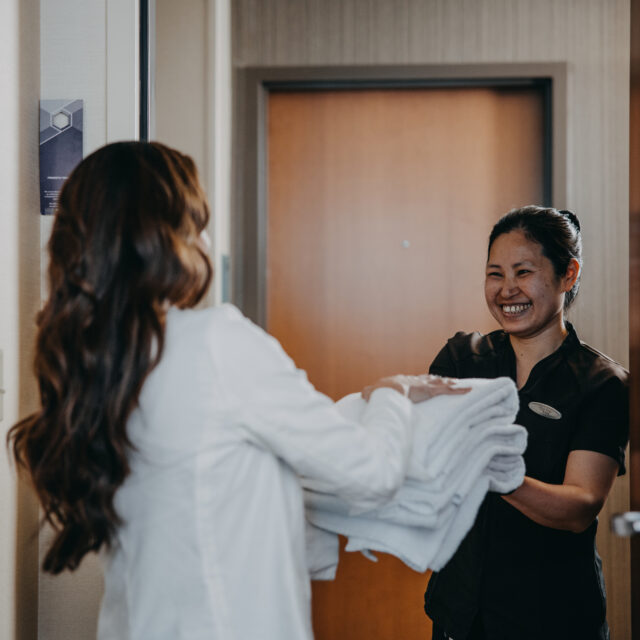 Hotel staff hands guest towels