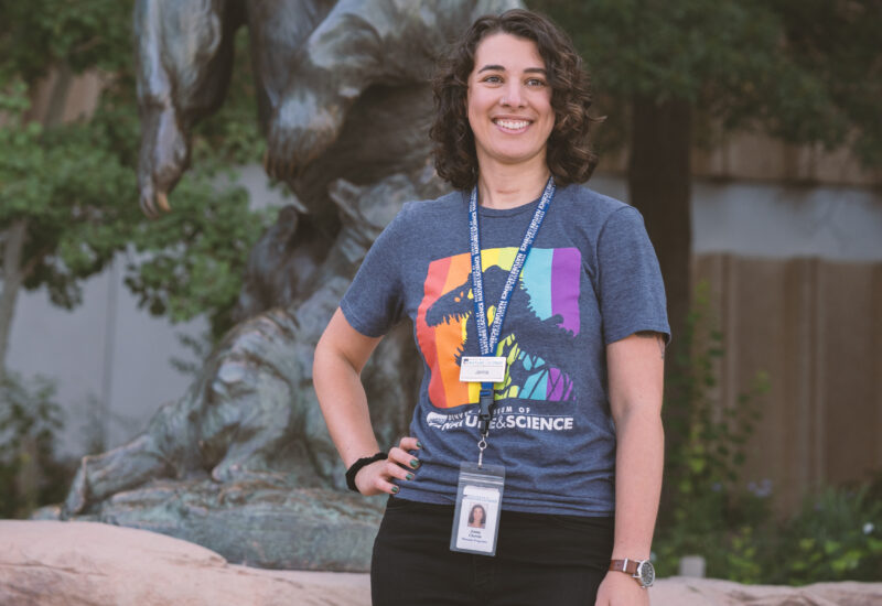 Jenna, an attractions ambassador, standing in front of a bear statue